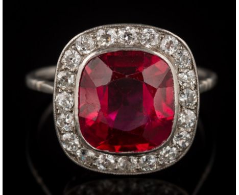 A synthetic ruby and diamond cushion shaped cluster ring: the synthetic ruby approximately 11.5mm long x 10.5mm wide x 5.5mm 