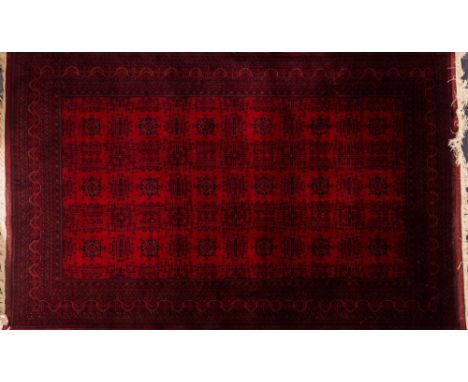 A Turkoman carpet:, of similar design with a main red field, 306cm x 203cm.