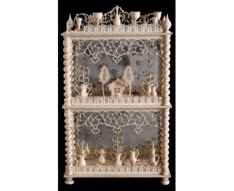 A 19th century Dieppe ivory miniature three tier dumb waiter: each shelf laden with miniature goblets, cups and saucers, vase