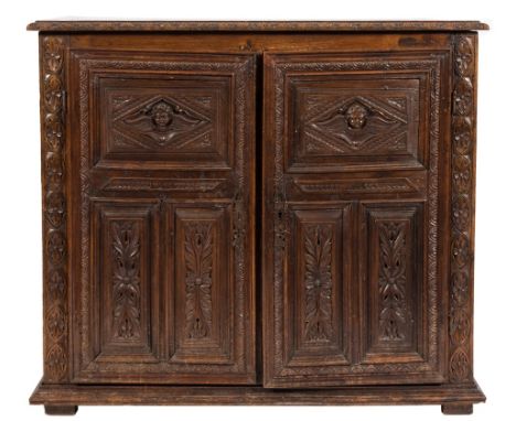 A part 17th Century and later Italian carved oak side cupboard:, the top with a lunette palmette edge, enclosed by a pair of 