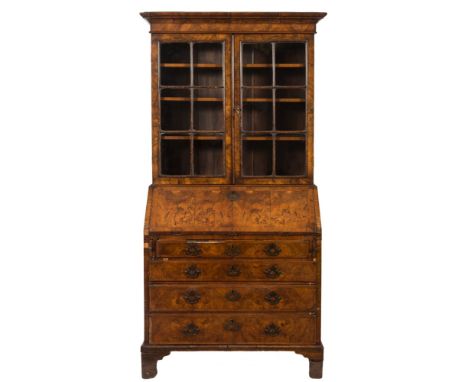 An 18th Century walnut bureau bookcase:, the upper part with a moulded cornice, fitted with fixed shelves enclosed by a pair 