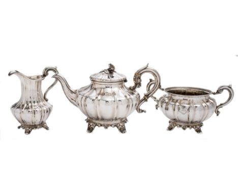 A matched silver three-piece tea service, various maker's and dates: of fluted melon-shaped outline, raised on swept foliate 