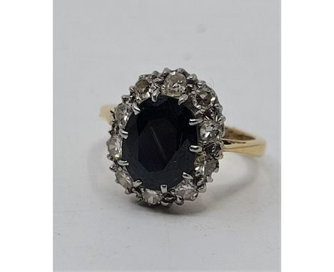 An 18ct. gold and platinum, sapphire and diamond ring, having mixed oval cut sapphire to centre (ESW 1.3 carats), bordered by