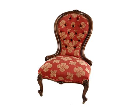 A VICTORIAN WALNUT GRANDMOTHER CHAIR the curved button-back within a conforming frame centred by a foliate carving, on carved