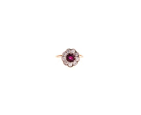 A RUBY AND DIAMOND RING centred with a circular mixed-cut ruby weighing approximately 1.29cts, surrounded by nine old-cut dia