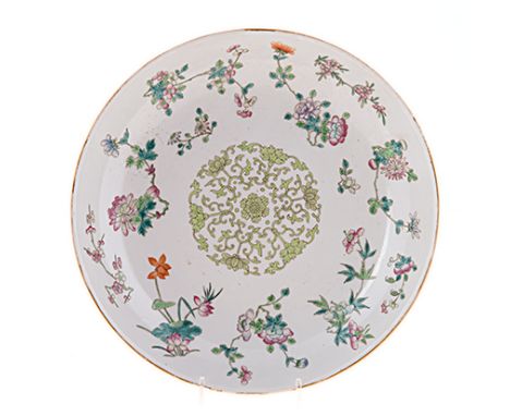 A CHINESE FAMILLE VERT DISH, LATE 19TH CENTURY painted with a central green floral motif within a scattered band of pink, lil