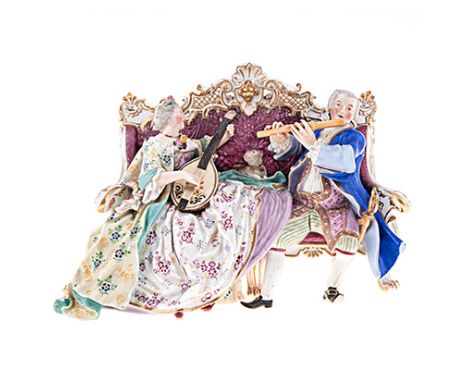 A MEISSEN PORCELAIN GROUP OF TWO MUSCIANS SEATED ON A CANAPE, 19TH CENTURY the lady and her companion playing a duet of flute