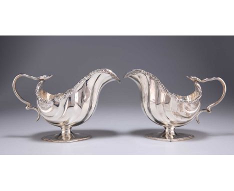 A PAIR OF LATE VICTORIAN SILVER SAUCEBOATS by Thomas Hayes, Birmingham 1898, with chased foliate borders, serpent double scro