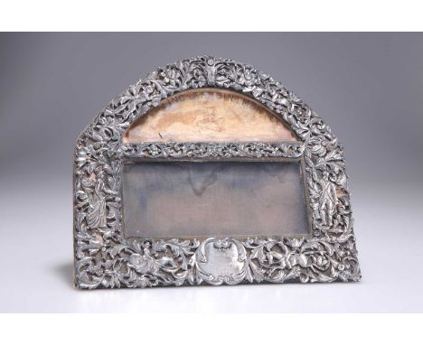 † A VICTORIAN SILVER-MOUNTED FRAME by William Comyns &amp; Sons, London 1888, the foliate pierced-work surround cast with a s