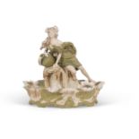 A Royal Dux Art Nouveau centrepiece shaped as a maiden above a bowl decorated with lillies, pink