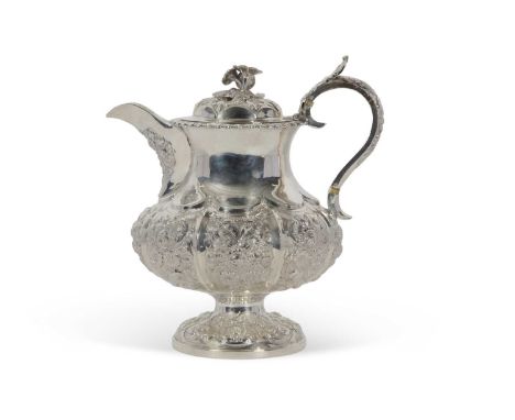 George IV silver hot water jug profusely embossed with flowers and scrolls, the spout modelled with floral detail, the handle