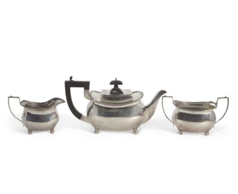 A matched three piece tea service of plain form with cantered corners and applied gadrooned rims, each supported on four ball