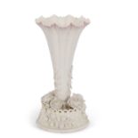 A Belleek trumpet shaped vase the base with finely modelled flower heads with a basket, Belique