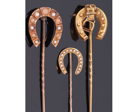 Three cased horseshoe stick pins, the first a coral and split pearl stick pin in unmarked yellow metal, 18mm wide, 3.2g; a st