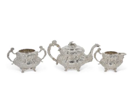 An Irish silver three piece tea service comprising teapot, sugar bowl and cream jug of compressed melon form, each elaboratel