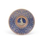 A Cantagalli lustre dish decorated in Hispano-Moresque style with a cherub to the centre on blue