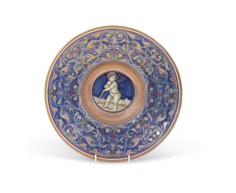 A Cantagalli lustre dish decorated in Hispano-Moresque style with a cherub to the centre on blue ground within foliate lustre