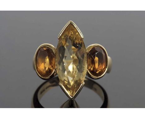 An 18ct golden beryl and citrine ring, the central marquise golden beryl, 18.4mm long, with a round citrine to either side, w