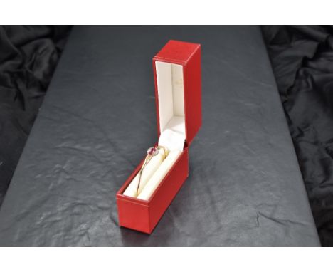 A 9ct gold hinged bangle having a small ruby and diamond set panel to front, approx 6.5g