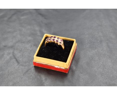 A ruby and diamond ring having a double row of collar set rubies interspersed by a row of diamond chips on a yellow metal loo