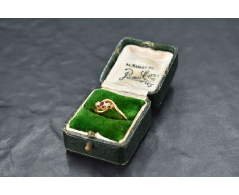 A diamond and ruby trio ring having cross over shoulders on an 18ct gold loop, size M &amp; approx 2.7g