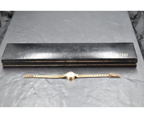 A lady's 9ct gold Rotary wrist watch having baton numeral dial to circular champagne face in gold case with bark effect 9ct g