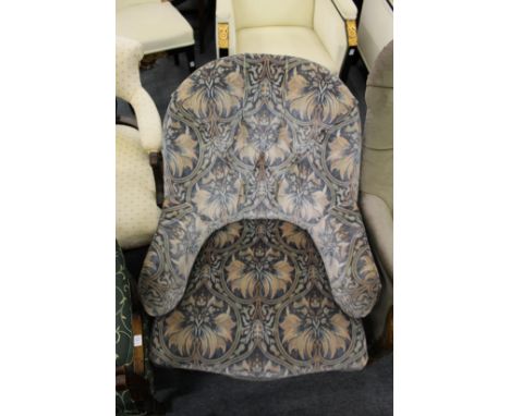 A Victorian button back armchair on turned front legs