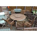 A large folding circular table with lazy susan centre piece, six folding armchairs with cushions