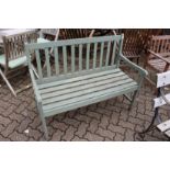 A green painted wooden garden bench