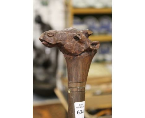 A hardwood walking stick the handle carved as a camels head