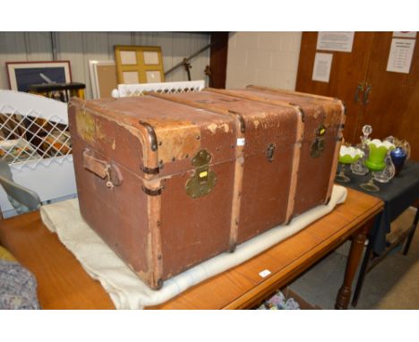 An early 20th Century wooden bound and leather travelling trunk with some original labels 