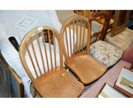 A pair of elm sated stick back kitchen chairs 