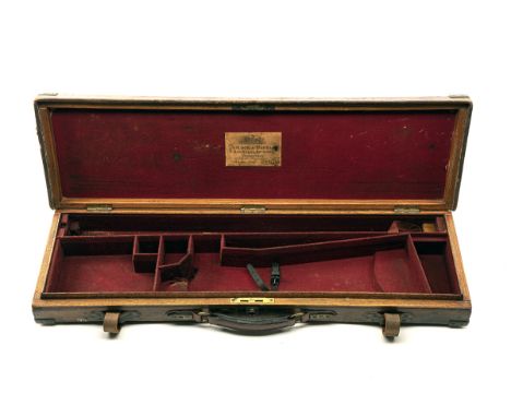 A BRASS-CORNERED OAK AND LEATHER GUNCASE, fitted for 30in. barrels, the interior lined with red baize, a Trulock &amp; Harris