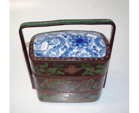 Chinese three tier lacquer ware food basket with blue and white ceramic top