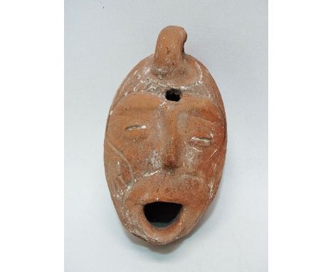 A Truscan style terracotta oil lamp, modelled as a mask, height 10cm. 