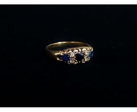A 9ct gold ring set three sapphires and four diamonds, the diamonds of .08ct spread approximately, size N.
