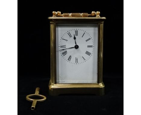 A brass cased carriage clock with white enamel dial and Roman numerals, height 12cm. 