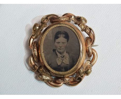 A Victorian gold mourning brooch set portrait photographs.