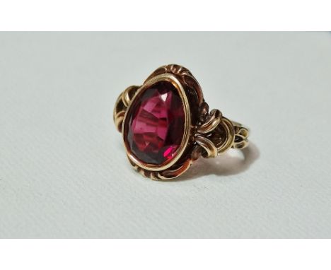 A Victorian 9ct gold dress ring set a large pear shape faceted garnet, size O.