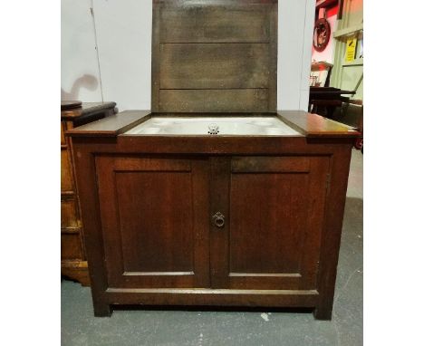 A late 19th century oak Gothic style washstand, the rising top with a fitted ceramic basin with compartments for soap and bru