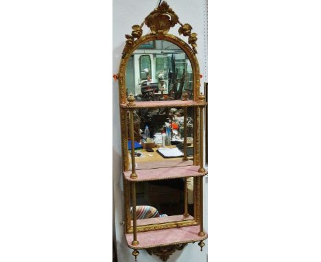 A 19th century pier mirror with gilt gesso frame and three shelf supports, capped with a shell and scrolling flower crest, he