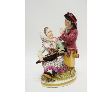 A late 19th/early 20th century continental porcelain figure group of a lady musician and a gentleman holding a lamp, blue and
