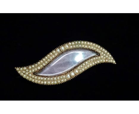 A George III gold and seed pearl set leaf shaped mourning brooch, set a glazed panel.