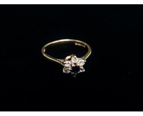 A modern 18ct hallmarked gold diamond and sapphire set seven stone daisy ring, the diamonds each of 0.03ct spread approximate