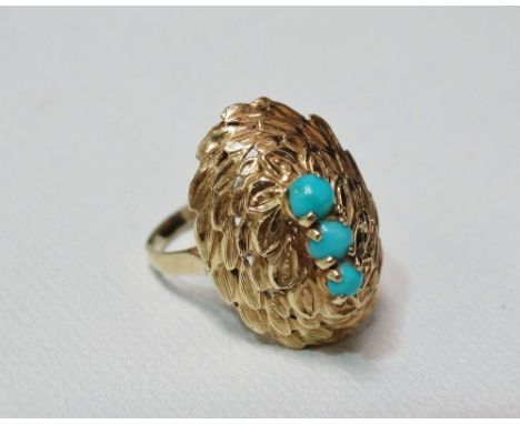 A 9ct gold three stone turquoise ring, decorated with a spiral of stylised laurel leaves, size M, weight 4.3g.