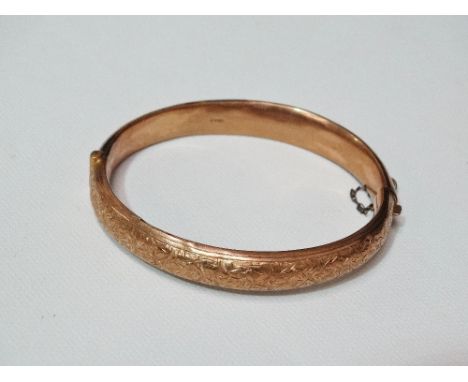 A 9ct gold child's hinged bangle with engraved ivy leaf design, weight 11g.