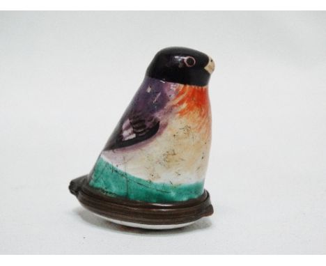A Bilston enamel bird patch box, circa 1780, modelled as a seated bird, the hinged base and cover painted with a spray of flo