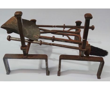 An Arts and Crafts Archibald Carne of Truro, wrought iron fire dogs and tools set.