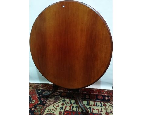 A Victorian mahogany tilt top centre table raised on a turned support with tripod carved legs and brass and ceramic castors, 