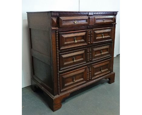 A late 17th/early 18th century oak chest of drawers, the moulded top over four graduated mitre moulded drawer fronts, the low